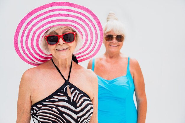 Gelukkige oudere vrouwen die een feestje hebben in het zwembad - Oudere vrienden ontspannen op een zwembadfeestje