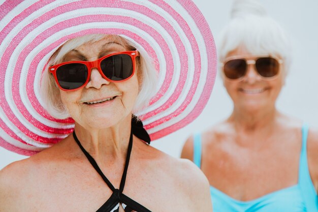 Gelukkige oudere vrouwen die een feestje hebben in het zwembad - Oudere vrienden ontspannen op een zwembadfeestje