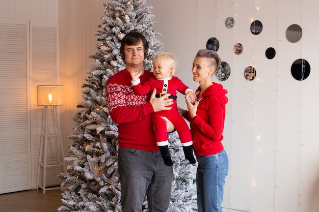 Gelukkige ouders en hun schattige zoon die thuis op Kerstmis wachten. Familie kerst thuis.