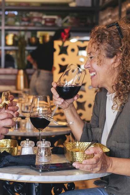 Gelukkige paar glimlachend en pratend in een restaurant dat rode wijn drinkt Echtpaar met lunchpauze in café-bar Lifestyle concept met man en een vrouw die uitgaan op weekenddag