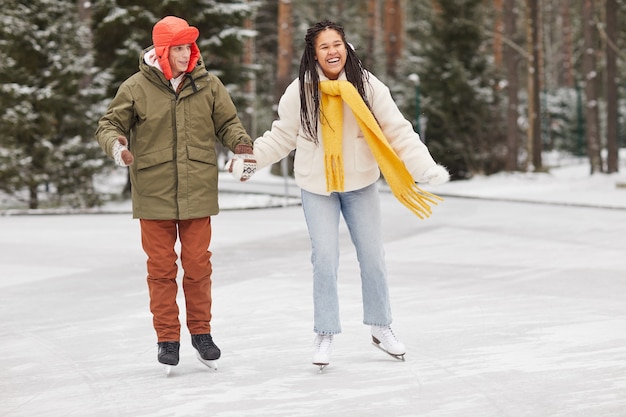 Gelukkige paar hand in hand samen schaatsen in de winter woud