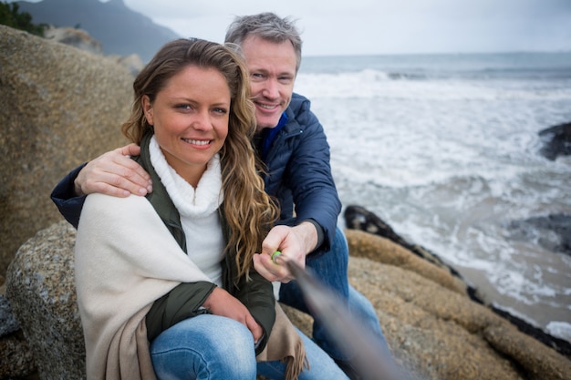 Gelukkige paar nemen een selfie op het strand