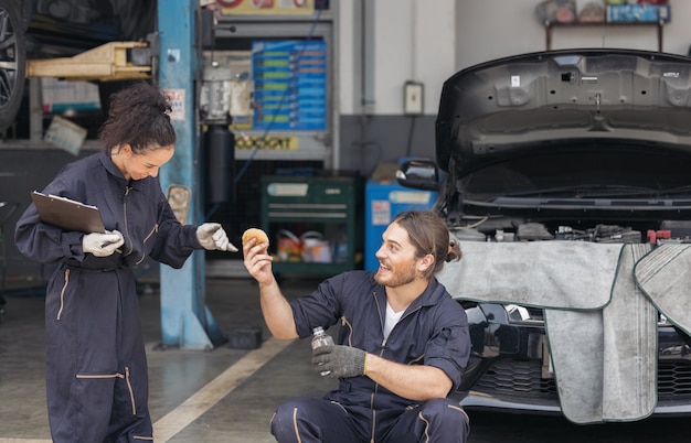 Gelukkige paar nemen hun auto voor service en wachten ontspannen tijd bij garage