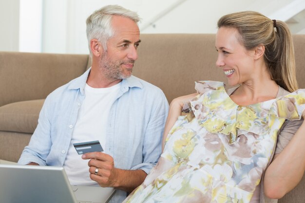 Foto gelukkige paar online winkelen op de bank