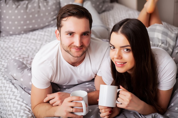 Gelukkige paar plezier in bed. Intiem sensueel jong koppel in de slaapkamer genieten van elkaar