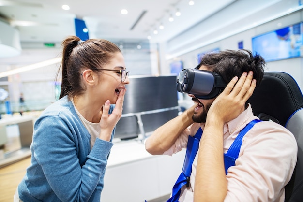 Gelukkige paar plezier met RV-bril terwijl jongen in haar in tech store zit.