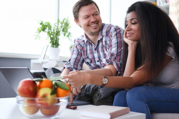 Gelukkige paar praten thuis aan tafel op Bank