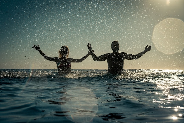 Gelukkige paar spelen in de zee Man en vrouw plezier op zomervakantie Gezonde actieve levensstijl concept lifestyle