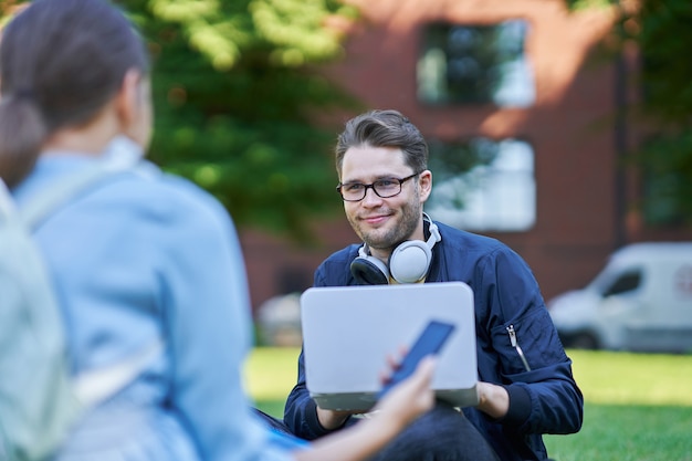 gelukkige paar studenten op de campus die buiten studeren