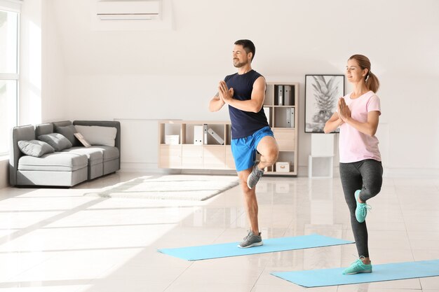 Gelukkige paar verliefd doen yoga thuis