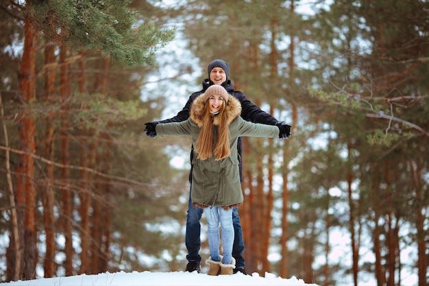 Gelukkige paar verliefd omarmen in besneeuwde winter koude bos, liefde en relaties