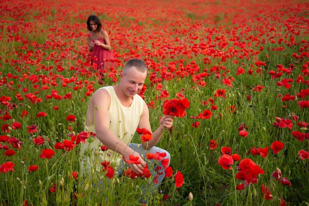 Gelukkige paar verliefd tederheid op papaver lente veld. welzijn vriend vriendin familie, landelijke natuur.