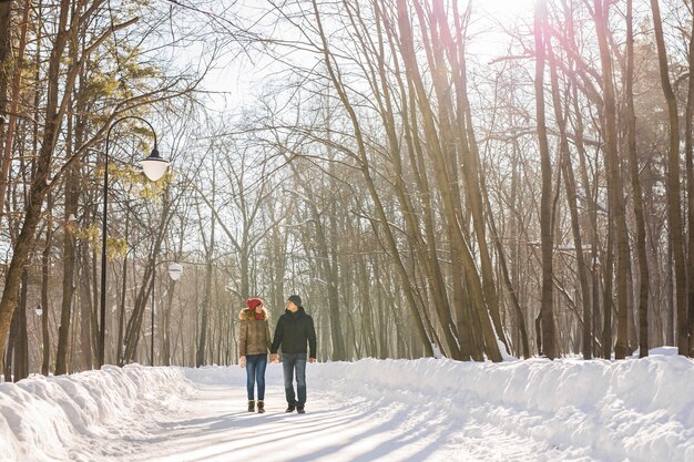Gelukkige paar wandelen door een besneeuwd bos in de winter.