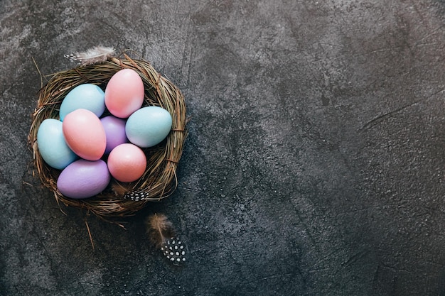 Gelukkige paasconcept voorbereiding voor de feestdag kleurrijke pastel versierde paaseieren in nest op grunge