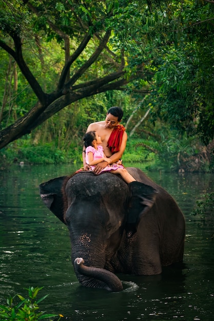 Gelukkige papa en dochterzitting op de olifant, Thailand