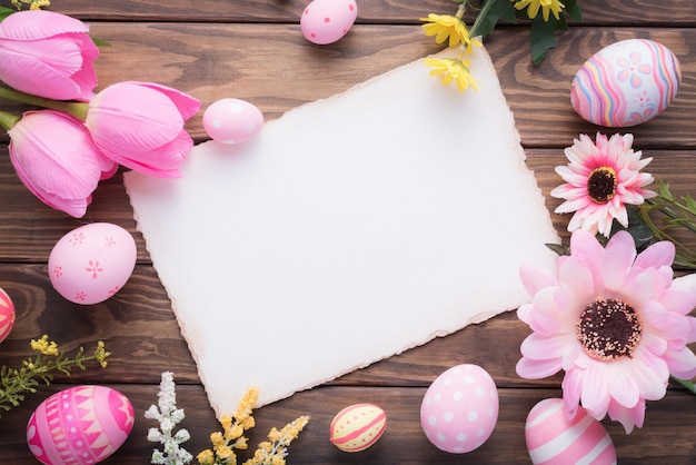 Gelukkige Pasen-dag roze eieren en bloemdecoratie op hout