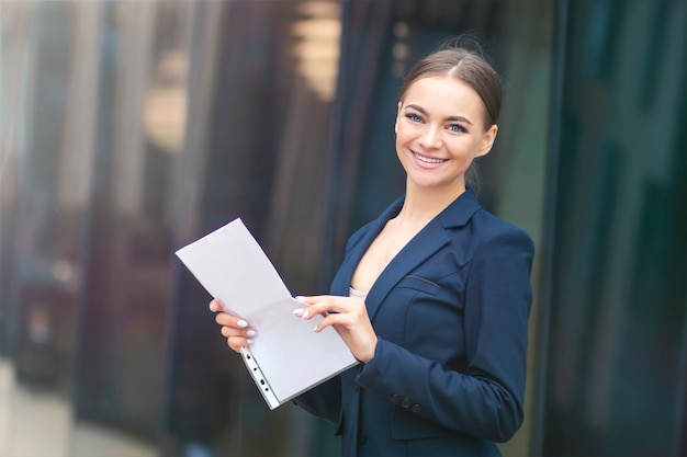 Gelukkige positieve succesvolle mooie vrouw met documenten