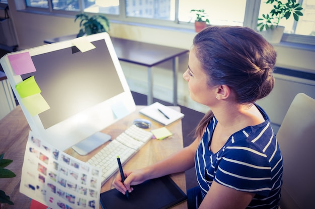 Foto gelukkige redacteur die bij haar bureau werkt