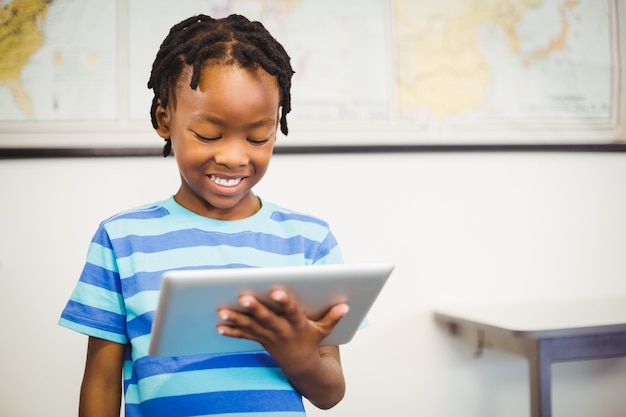 Gelukkige schooljongen die digitale tablet in klaslokaal gebruiken