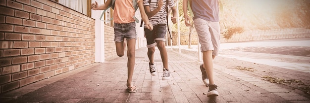 Gelukkige schoolkinderen rennen in de gang