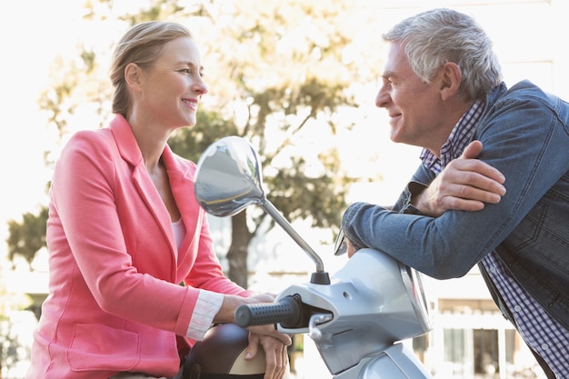 Gelukkige senior paar poseren met hun bromfiets