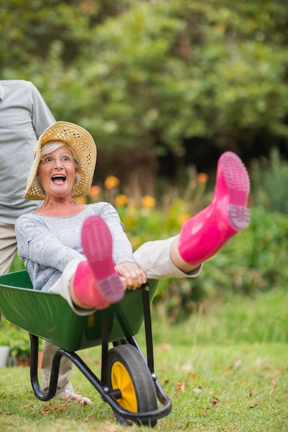 Gelukkige senior paar spelen met een kruiwagen