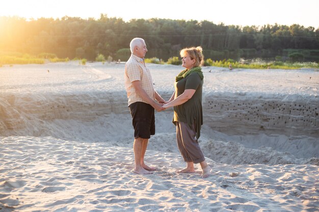 Gelukkige senior paar verliefd buiten in strand in de zomer de natuur