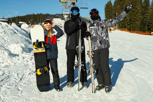 Gelukkige skiërs in bergresort in zonnige dag