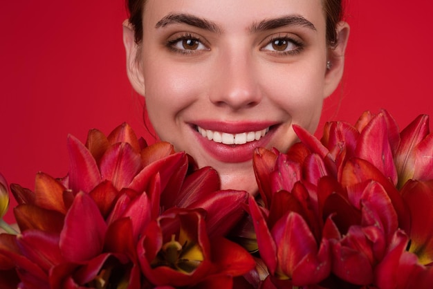 Gelukkige smiligvrouw met het meisje van de bloemenschoonheid met tulp mooi sensueel de tulpenboeket van de vrouwengreep s