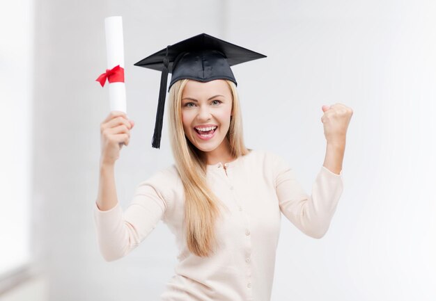 Foto gelukkige student in afstudeerpet met certificaat