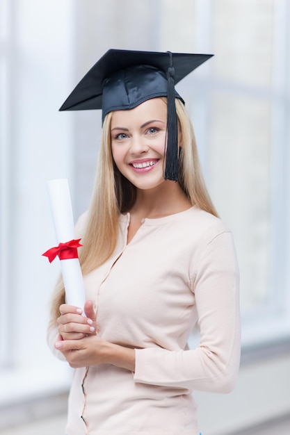 gelukkige student in afstudeerpet met certificaat