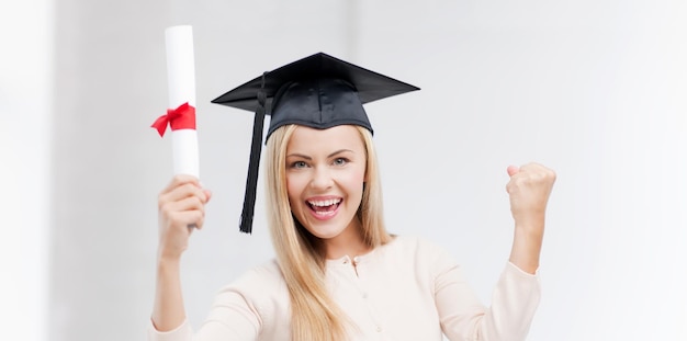 Foto gelukkige student in afstudeerpet met certificaat