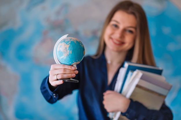 Foto gelukkige student met een wereldkaart aan de muur