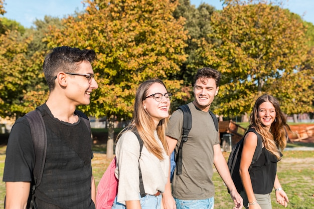 Gelukkige studenten bij park dat en pret glimlacht heeft