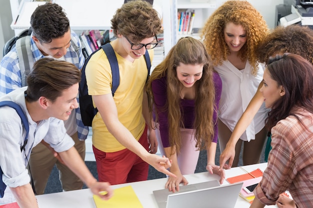 Foto gelukkige studenten die aan laptop samenwerken