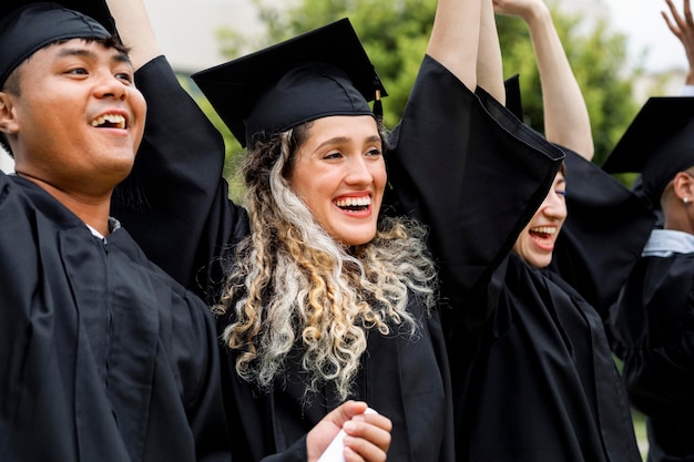 Gelukkige studenten die afstuderen aan de universiteit, vieren met diploma's