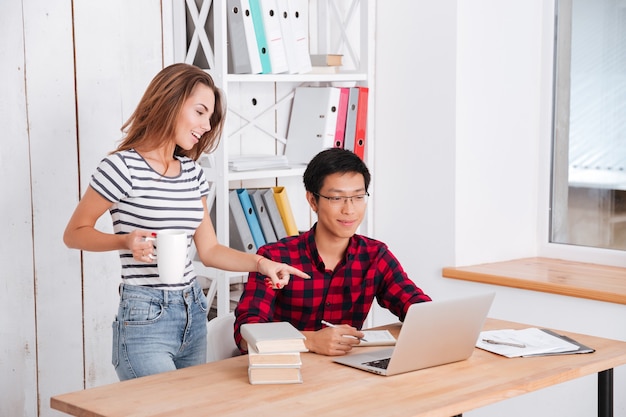 Gelukkige studenten die laptop bekijken