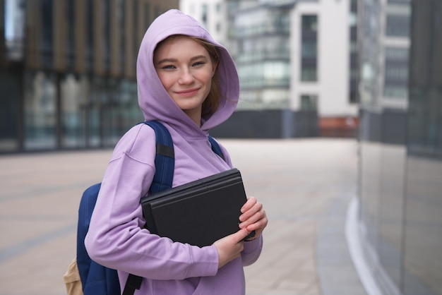 gelukkige tiener tiener meisje jonge vrouw universiteit of hogeschool academische student in hoodie met boeken