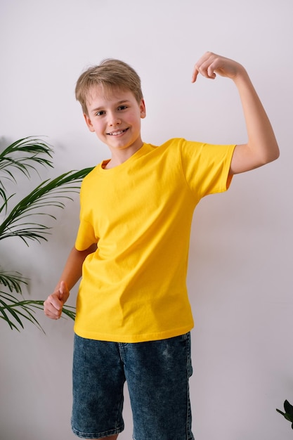 Gelukkige tiener wijzend op zijn t-shirt Geel t-shirtmodel