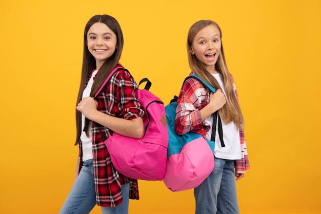 Gelukkige tienermeisjes dragen rugzak terug naar school kennisdag concept van onderwijs