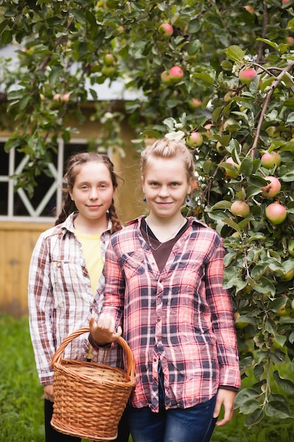 Gelukkige tienermeisjes in geruite overhemden in de zomer in de tuin