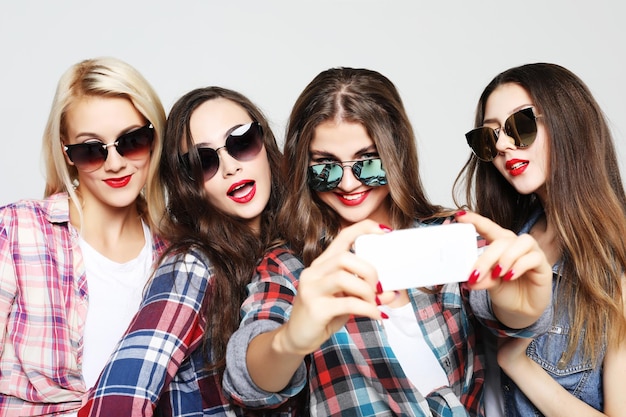 Gelukkige tienermeisjes met smartphone die selfie nemen