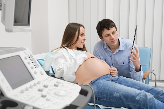 Gelukkige toekomstige ouders op echografie in kliniek.