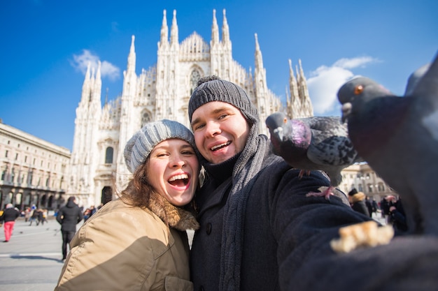 Gelukkige toeristen die een zelfportret met duiven nemen voor de kathedraal van Duomo, Milaan.