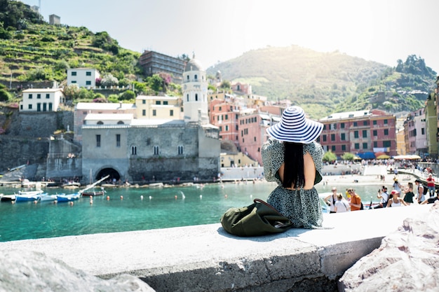 Gelukkige toeristenvrouw die toneelmening van oud dorp Vernazza bekijken