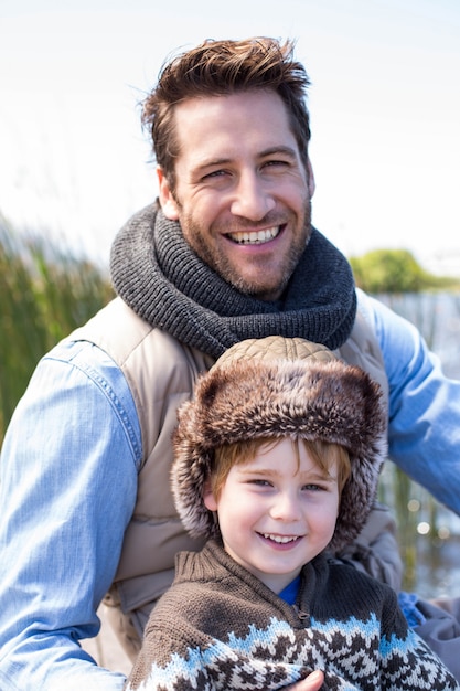 Foto gelukkige toevallige vader en zoon bij een meer