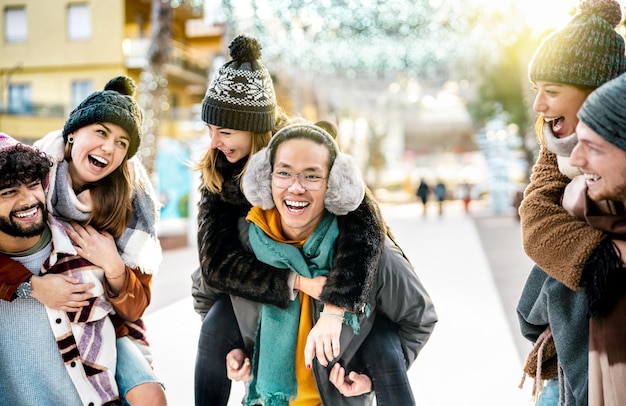 Gelukkige trendy vrienden wandelen op winterreislocatie op piggy back move