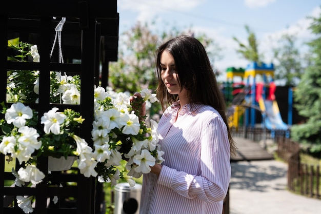 Gelukkige tuinmanvrouw plant bloemen op het bloembed in de eigen tuin Tuinieren en bloementeelt