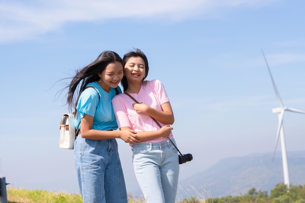 Gelukkige twee meisjes die samen naar de windturbines en de berg met blauwe lucht kijken Khao Yai Thieng Electric Wind Turbine Thailand