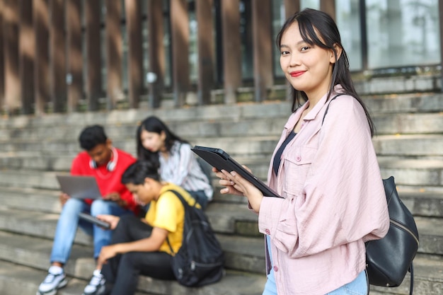 Gelukkige universiteitsstudent gaat naar een klas aan de universiteit en kijkt naar de camera